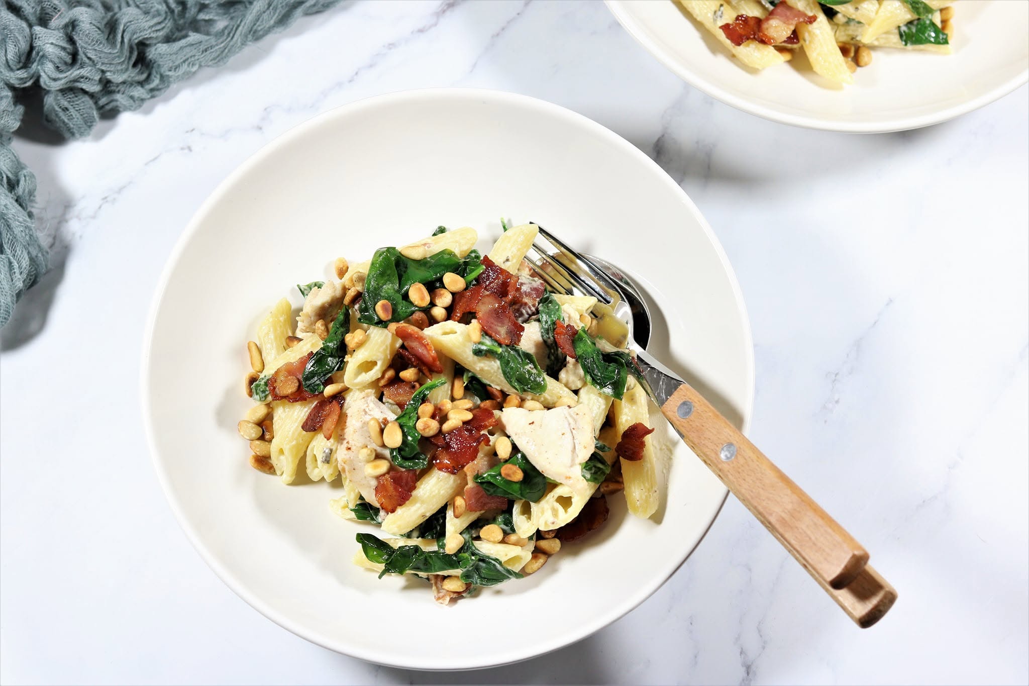 A colourful bowl of pasta with greens, served at home